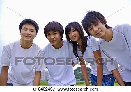 Four teenagers standing together and looking at the camera, Teenager View Large Photo Image Stock Photo - Four teenagers standing together and looking at the camera, Teenager. Fotosearch