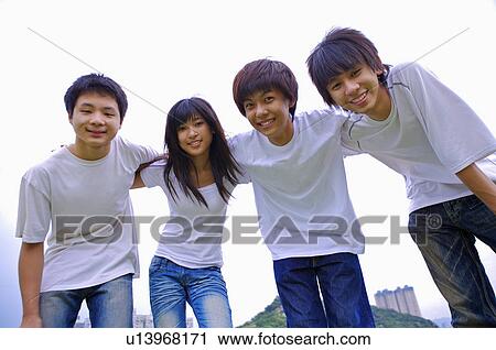 Four teenagers standing together with hands on shoulder and looking at the camera, Teenager View Large Photo Image Stock Image - Four teenagers standing together with hands on shoulder and looking at the camera, Teenager. Fotosearch