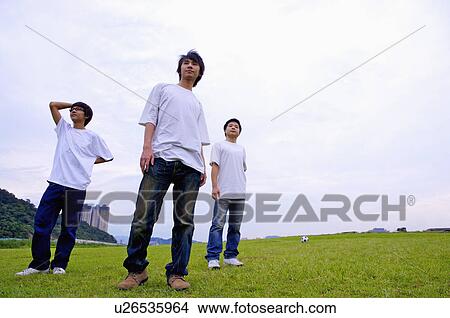 Three boys standing on the lawn and looking away, Teenager View Large Photo Image Picture - Three boys standing on the lawn and looking away, Teenager. Fotosearch