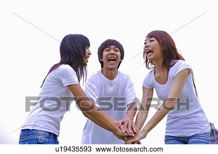 Three teenagers shouting and holding hands in a stack, Teenager View Large Photo Image Stock Image - Three teenagers shouting and holding hands in a stack, Teenager. Fotosearch