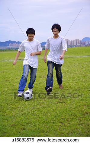 Two boys playing football on the lawn, Teenager View Large Photo Image Stock Photograph - Two boys playing football on the lawn, Teenager. Fotosearch