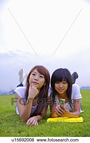 Two girls lying on the lawn together, Teenager View Large Photo Image Stock Photo - Two girls lying on the lawn together, Teenager. Fotosearch
