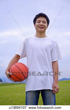 Young boy holding a basketball and smiling, Teenager View Large Photo Image Stock Photo - Young boy holding a basketball and smiling, Teenager. Fotosearch