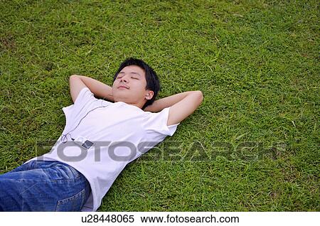 Young boy lying on the lawn with eyes closed and listening music, Teenager View Large Photo Image Stock Photography - Young boy lying on the lawn with eyes closed and listening music, Teenager. Fotosearch