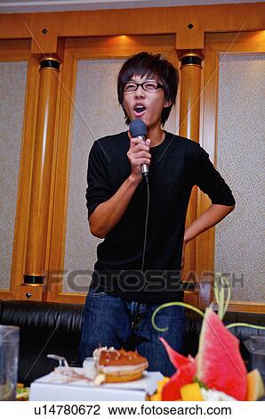 Teenager boy holding microphone and singing with hands akimbo, Teenager View Large Photo Image Stock Image - Teenager boy holding microphone and singing with hands akimbo, Teenager. Fotosearch