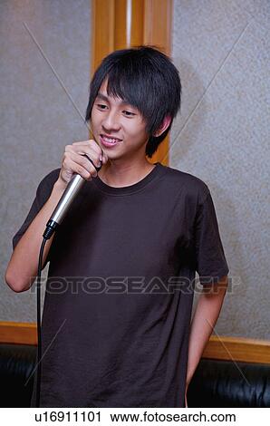 Teenager boy holding microphone and singing with smile, Teenager View Large Photo Image Stock Image - Teenager boy holding microphone and singing with smile, Teenager. Fotosearch