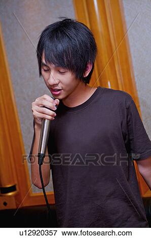 Teenager boy holding microphone and singing, eyes closed View Large Photo Image Stock Photo - Teenager boy holding microphone and singing, eyes closed. Fotosearch