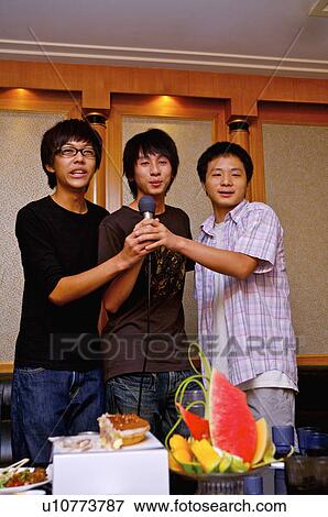 Teenager boys holding a microphone and singing together, Teenager View Large Photo Image Stock Photo - Teenager boys holding a microphone and singing together, Teenager. Fotosearch