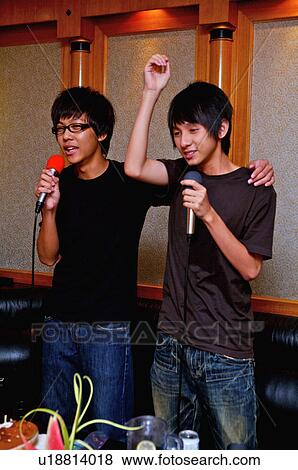 Stock Photo - Teenager boys holding microphone and singing with hands on shoulder, Teenager. Fotosearch