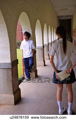 Teenager girl hiding an envelope for a teenager boy, Teenager View Large Photo Image Stock Photo - Teenager girl hiding an envelope for a teenager boy, Teenager. Fotosearch