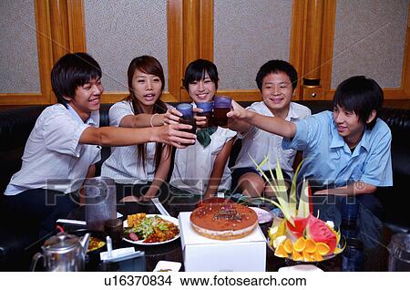 Picture - Teenagers celebrating and holding glasses together, Teenager. Fotosearch