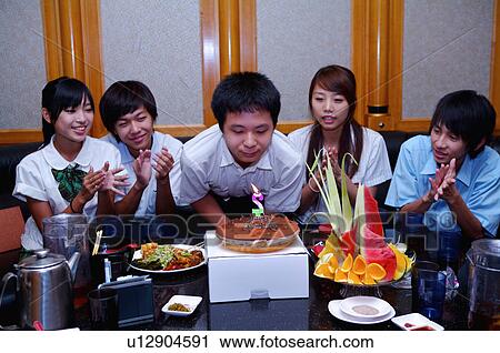 Stock Image - Teenagers celebrating birthday for a boy and applauding together, Teenager. Fotosearch