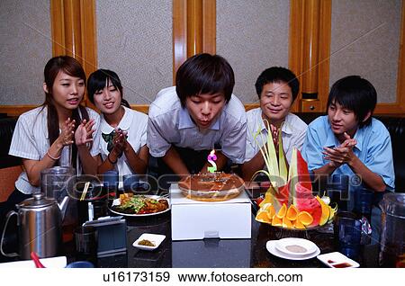Stock Photo - Teenagers celebrating birthday for a boy and applauding together, Teenager. Fotosearch