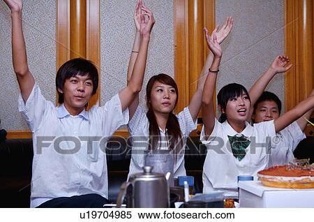 Stock Photography - Teenagers celebrating for birthday with arms raised together, Teenager. Fotosearch