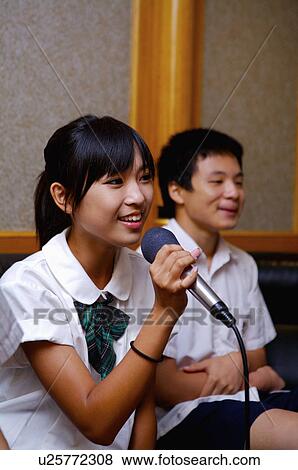 Stock Photo - Teenagers holding microphone and singing, Teenager. Fotosearch