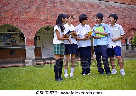 Teenagers standing on the lawn with books and discussing, Teenager View Large Photo Image Stock Photo - Teenagers standing on the lawn with books and discussing, Teenager. Fotosearch