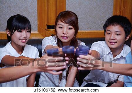 Teenagers toasting with drinks and celebrating happily View Large Photo Image Stock Image - Teenagers toasting with drinks and celebrating happily. Fotosearch