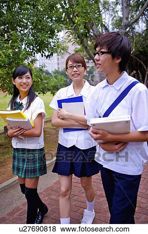 Stock Photo - Teenagers walking in the campus with books in hand and smiling, Teenager. Fotosearch
