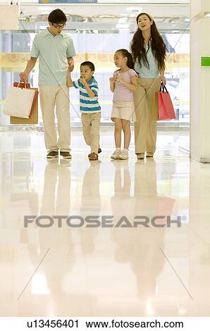 若い 家族 で ２人の子供たち 買い物 一緒に そして 保有物 買い物袋 家族 レジャー活動 ストックイメージ U Fotosearch