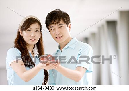 Couple holding a house model together and looking at the camera, Family, Leisure Activities View Large Photo Image Stock Photo - Couple holding a house model together and looking at the camera, Family, Leisure Activities. Fotosearch