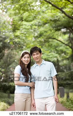 Stock Image - Couple standing together and smiling at the camera, Family, Leisure Activities. Fotosearch