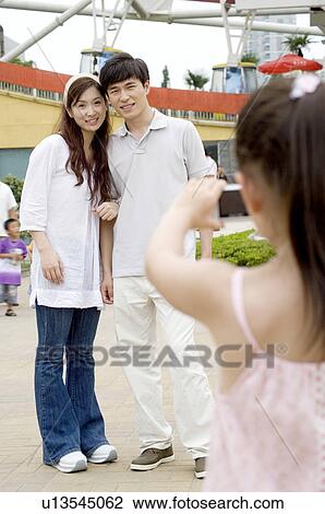 Couple standing together and taking pictures by little girl, Family, Leisure Activities View Large Photo Image Stock Image - Couple standing together and taking pictures by little girl, Family, Leisure Activities. Fotosearch