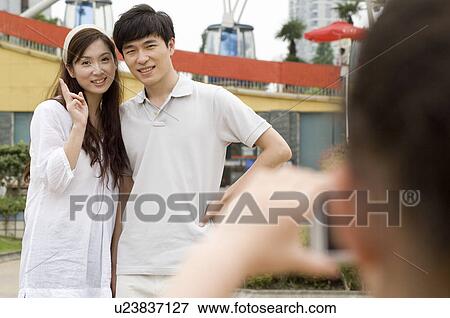 Couple taking pictures and gesturing with smile, Family, Leisure Activities View Large Photo Image Stock Photo - Couple taking pictures and gesturing with smile, Family, Leisure Activities. Fotosearch