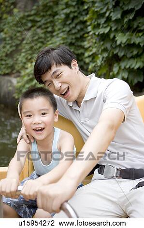 Stock Image - Little boy and man playing together and smiling happily, Family, Leisure Activities. Fotosearch