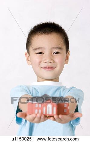 Little boy holding a house model and smiling at the camera, Family, Leisure Activities View Large Photo Image Stock Image - Little boy holding a house model and smiling at the camera, Family, Leisure Activities. Fotosearch