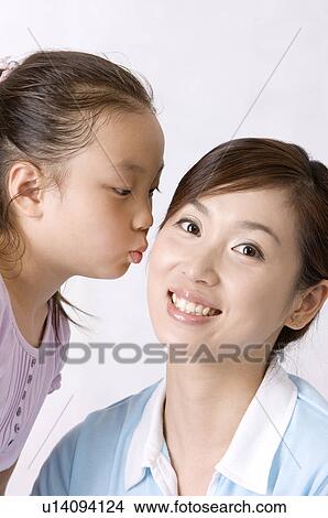 Picture - Little girl kissing on young woman's face with smile, Family, Leisure Activities. Fotosearch