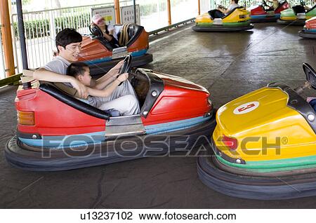 Man and little boy playing bumper car and looking at the camera, Family, Leisure Activities View Large Photo Image Stock Image - Man and little boy playing bumper car and looking at the camera, Family, Leisure Activities. Fotosearch