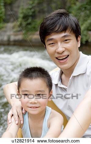 Man and little boy playing near the river and smiling, Family, Leisure Activities View Large Photo Image Picture - Man and little boy playing near the river and smiling, Family, Leisure Activities. Fotosearch