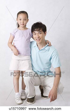 Man crouching with little girl and smiling at the camera, Family, Leisure Activities View Large Photo Image Stock Photo - Man crouching with little girl and smiling at the camera, Family, Leisure Activities. Fotosearch