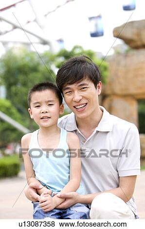 Man holding little boy and smiling at the camera, Family, Leisure Activities View Large Photo Image Stock Photo - Man holding little boy and smiling at the camera, Family, Leisure Activities. Fotosearch