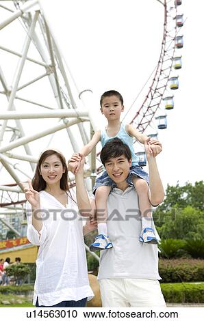 Young family with a little boy standing before ferries wheel together and smiling, Family, Leisure Activities View Large Photo Image Stock Image - Young family with a little boy standing before ferries wheel together and smiling, Family, Leisure Activities. Fotosearch