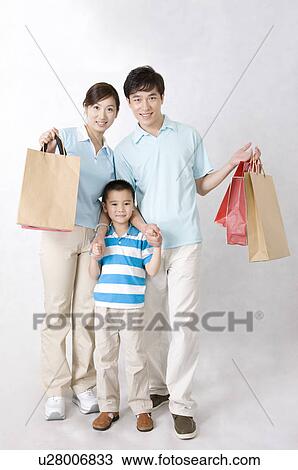Young family with little boy standing together and holding shopping bags, Family, Leisure Activities View Large Photo Image Stock Image - Young family with little boy standing together and holding shopping bags, Family, Leisure Activities. Fotosearch