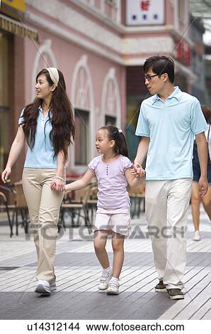 Young family with little girl holding hands together and walking on the road, Family, Leisure Activities View Large Photo Image Picture - Young family with little girl holding hands together and walking on the road, Family, Leisure Activities. Fotosearch