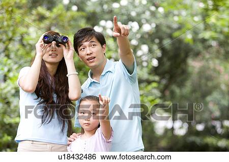 Young family with little girl pointing and looking up with a telescope, Family, Leisure Activities View Large Photo Image Stock Photograph - Young family with little girl pointing and looking up with a telescope, Family, Leisure Activities. Fotosearch