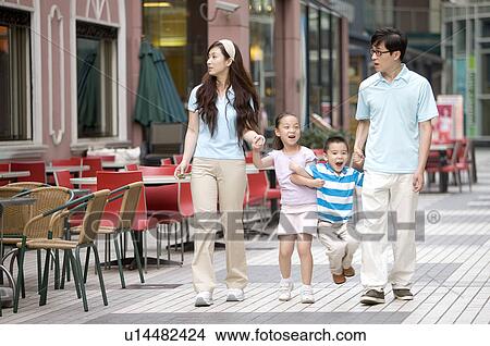 Young family with two children holding hands together and walking on the road, Family, Leisure Activities View Large Photo Image Picture - Young family with two children holding hands together and walking on the road, Family, Leisure Activities. Fotosearch