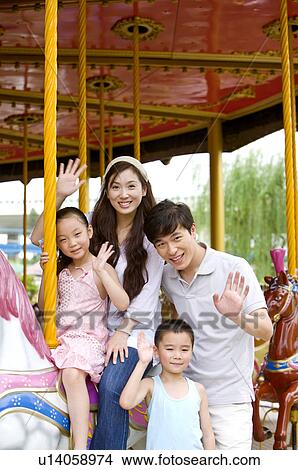 Young family with two children playing carrousel and gesturing with smile, Family, Leisure Activities View Large Photo Image Picture - Young family with two children playing carrousel and gesturing with smile, Family, Leisure Activities. Fotosearch