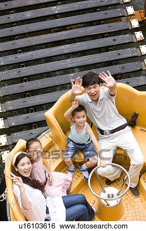 Young family with two children playing in the amusement park and looking up with gesturing, Family, Leisure Activities View Large Photo Image Stock Photograph - Young family with two children playing in the amusement park and looking up with gesturing, Family, Leisure Activities. Fotosearch