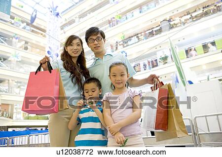Young family with two children standing together and holding shopping bags, Family, Leisure Activities View Large Photo Image Stock Image - Young family with two children standing together and holding shopping bags, Family, Leisure Activities. Fotosearch