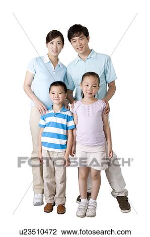 Stock Image - Young family with two children standing together and looking at the camera,, Family, Leisure Activities. Fotosearch