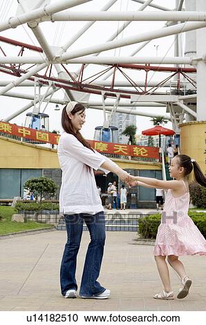 Young woman and little girl holding hands together and playing, Family, Leisure Activities View Large Photo Image Stock Image - Young woman and little girl holding hands together and playing, Family, Leisure Activities. Fotosearch