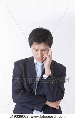 Stock Image - Portrait of man looking down and contemplating, Men, Facial Expression. Fotosearch