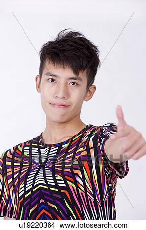 Picture - Portrait of young man smiling with thumbs up, Men, Facial Expression. Fotosearch