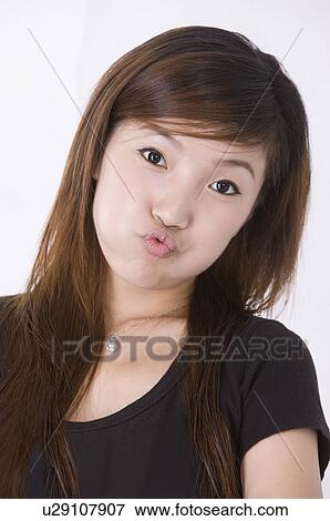 Portrait of young woman puckering, Women, Facial Expression View Large Photo Image Stock Photo - Portrait of young woman puckering, Women, Facial Expression. Fotosearch