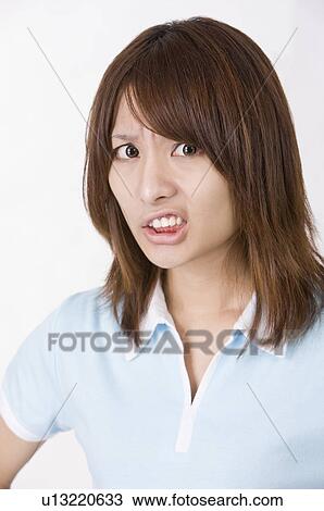 Stock Image - Portrait of young woman sulking, Women, Facial Expression. Fotosearch
