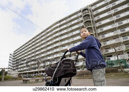 Boy holding baby buggy View Large Photo Image Stock Image - Boy holding baby buggy. Fotosearch
