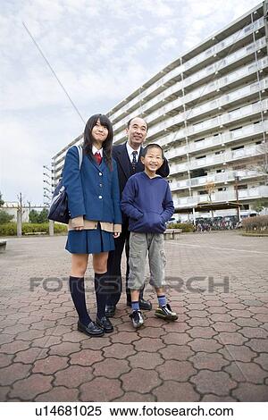 Stock Photography - Family standing in front of housing complex. Fotosearch